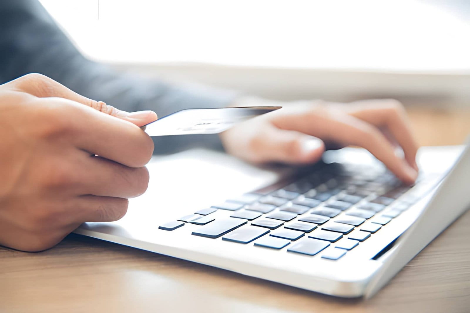 AMZ Digital FRA : Mains tenant la carte de crédit et tapant sur un ordinateur portable